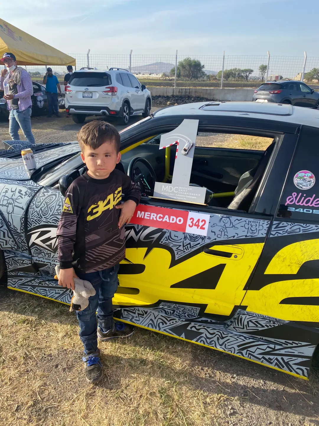 Su hijo junto al auto con el trofeo de primer lugar